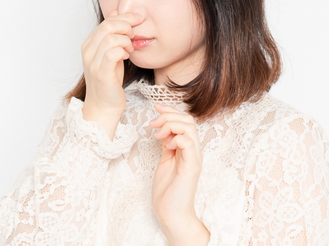 起きた時の口臭を確認する女性