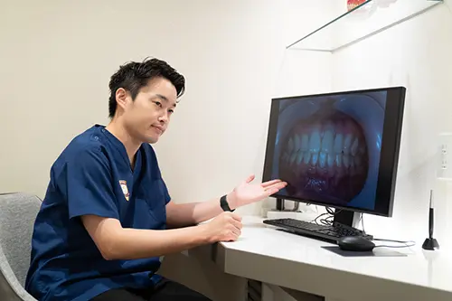 口腔内写真を診て説明をする歯科医師